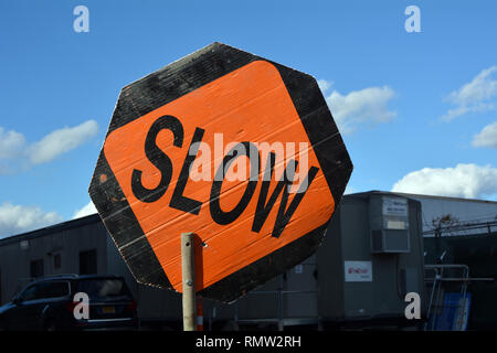 Slow Sign per la costruzione di strade e la sicurezza dei lavoratori Foto Stock