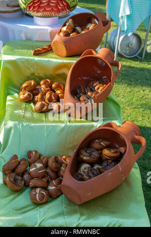 Pane appena sfornato panini con crostini di crosta croccante giacciono su una rotta Brown Jug. Il concetto di cottura per una cucina sana e gustosa. Foto Stock