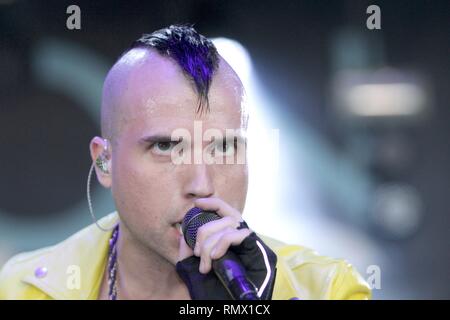 Il cantante e tastierista Tyler Glenn è mostrato esibirsi sul palco durante un 'live' aspetto di concerto con il neon di alberi. Foto Stock