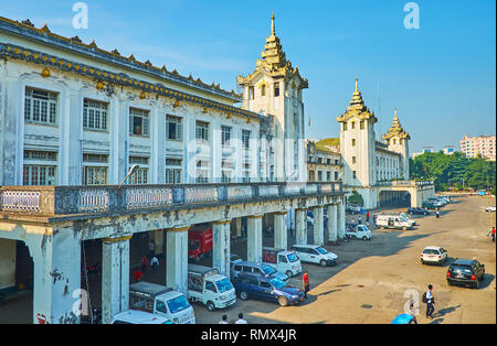 YANGON, MYANMAR - 15 febbraio 2018: la facciata del palazzo storico di Yangon stazione ferroviaria con portici, decorazioni scolpite e torri con tradit Foto Stock