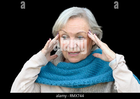 Confusi e disorientati senior lady tenendo le sue mani per i suoi templi come si guarda a parte, concettuale di insorgenza di demenza o morbo di Alzheimer Foto Stock