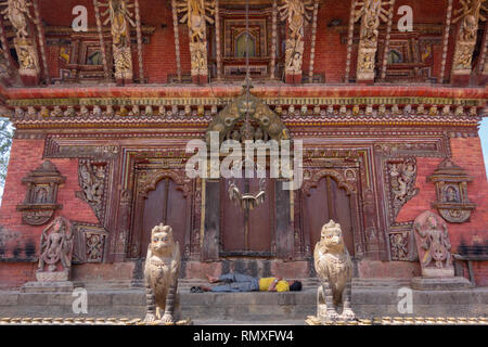 CHANGU NARAYAN, Bhaktapur, NEPAL-CIRCA 2013 : Unidentified uomo dorme in una porta di un antico tempio di Bhaktapur, Nepal. La maggior parte delle strutture a th Foto Stock