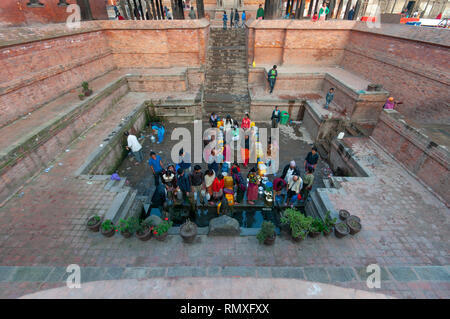 PATAN SQUARE, Kathmandu, Nepal-CIRCA 2013 : Unidentified nepalesi per raccogliere acqua fresca in un vicino tempio di Patan Square, Kathmandu, Nepal. Foto Stock