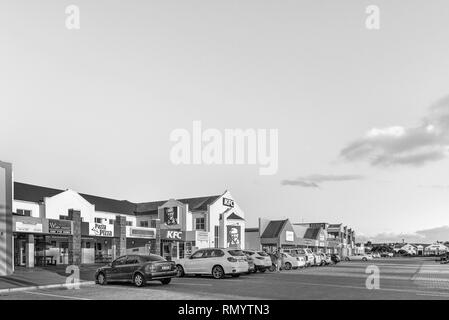 LANGEBAAN, SUD AFRICA, 20 agosto 2018: un tramonto scena di strada, con le imprese e i veicoli in Langebaan nella provincia del Capo occidentale. Monocromatico Foto Stock