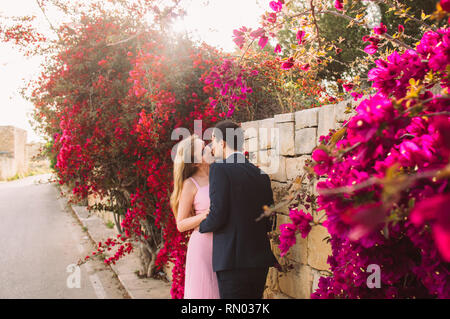 L uomo e la donna insieme a piedi e baciare in campagna, Malta Foto Stock