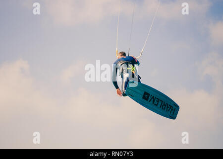 Immagine di un kite surfer di eseguire difficili acrobazie in venti alti. Extrme sport girato a Tarifa, Andalusia, Spagna Foto Stock