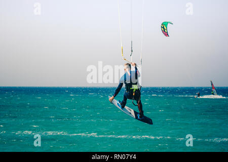 Immagine di un kite surfer di eseguire difficili acrobazie in venti alti. Extrme sport girato a Tarifa, Andalusia, Spagna Foto Stock