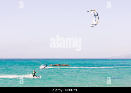 Immagine di un kite surfer di eseguire difficili acrobazie in venti alti. Extrme sport girato a Tarifa, Andalusia, Spagna Foto Stock