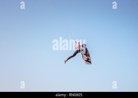 Immagine di un kite surfer di eseguire difficili acrobazie in venti alti. Extrme sport girato a Tarifa, Andalusia, Spagna Foto Stock