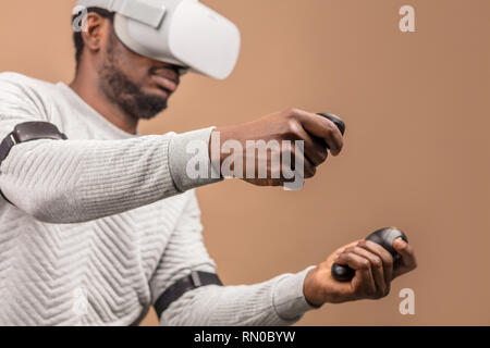 Uomo in VR occhiali ora è in corso di riproduzione 3D gioco ma l'umanità si erge sulla soglia di una nuova era di controllo degli oggetti in realtà virtuale dal reale giornate mondiali Foto Stock