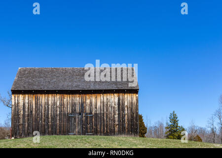 Grande fienile solo in piedi accanto ad alcuni alberi Foto Stock