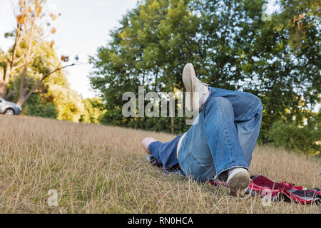Uomo appoggiato sul prato nel parco Foto Stock