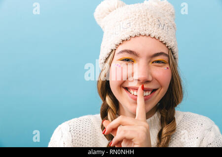 Bella ragazza di indossare abbigliamento invernale in piedi isolato su sfondo blu, ridendo Foto Stock