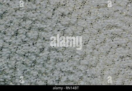 Transizione dei colori su un tessuto di lana cardigan da grigio a bianco. Macro che mostra dettagli gold flecks in lana. Foto Stock