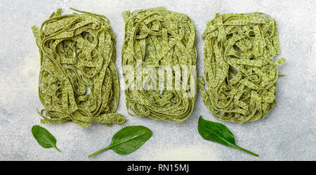 Materie casalingo italiano pasta verde spinaci tagliatelle. Asciugare gli spaghetti. Messa a fuoco selettiva, vista dall'alto Foto Stock