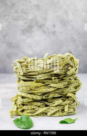 Materie casalingo italiano pasta verde tagliatelle con spinaci close-up. Asciugare gli spaghetti. Messa a fuoco selettiva, spazio di copia Foto Stock