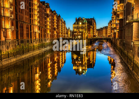 La storica Speicherstadt di Amburgo, Germania, di notte Foto Stock