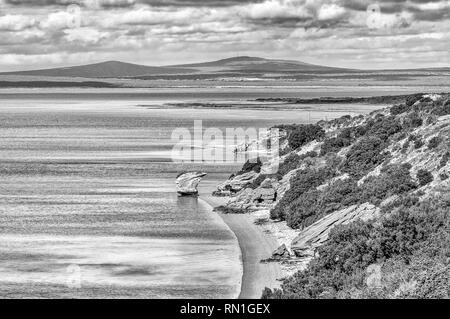 Vista della Laguna di Langebaan sulla costa dell'Oceano Atlantico nella provincia del Capo occidentale. Il Preekstoel (il pulpito) formazione di roccia è visibile. Monocromatico Foto Stock