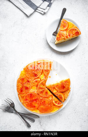 Sottosopra torta arancione su sfondo bianco, copia dello spazio. Torte fatte in casa con la sanguinosa arance, agrumi. Foto Stock