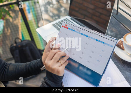 Puntando sul calendario con la penna per ricordare a chi la riunione Foto Stock