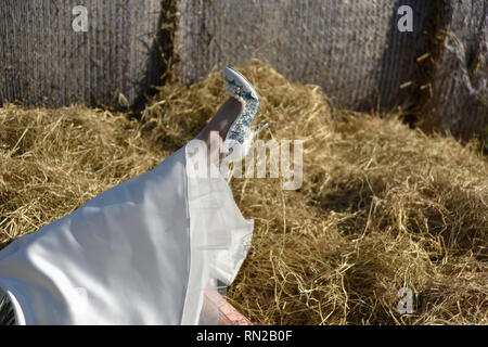 Un bel paio di sposarsi in un romantico Farm Ubicazione - lei è una rossa e wers un breve vintage abiti da sposa. Egli è alto e ha tatuaggi Foto Stock