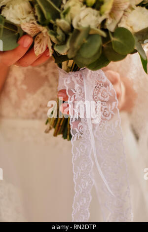 Sposa tenendo un luminoso Bouquet nozze con fiori diversi Foto Stock