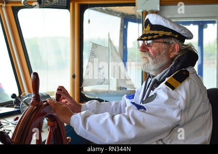 Navigazione della nave, capitano esperto, vecchio cane del mare con i capelli grigi e la barba sul suo posto di lavoro, nave cabine di navigazione Foto Stock