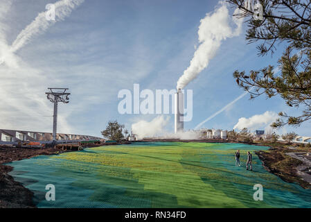 L uomo e la donna passeggiate nel verde della pista da sci sulla parte superiore del nuovo impianto di alimentazione in Copenhagen Foto Stock