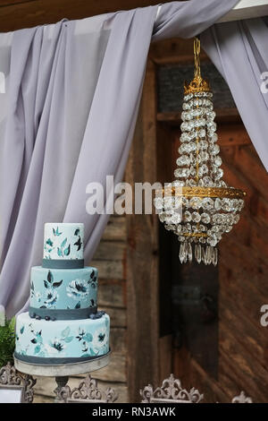 Bella blu a tre livelli la torta sul tavolo. Foto Stock