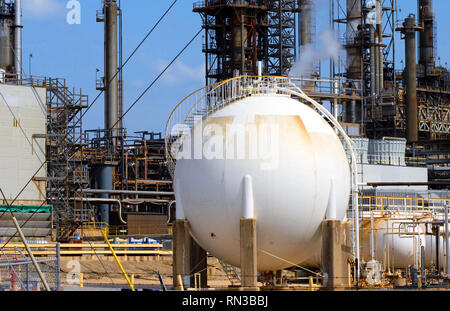 Bianco grande serbatoio di stoccaggio alla raffineria di petrolio ha scale a spirale di avvolgimento base intorno alla parte superiore del serbatoio. Foto Stock