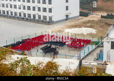 Dengfeng, Cina - 17 Ottobre 2018: l'uniforme di formazione degli alunni della scuola di arti marziali è essiccato su una fune in strada dopo il lavaggio. Il Tempio Shaolin e. Foto Stock