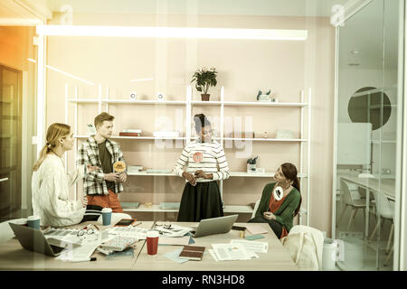 Ufficio lavoratori tenendo colorati cappelli pensando a condividere le loro idee Foto Stock