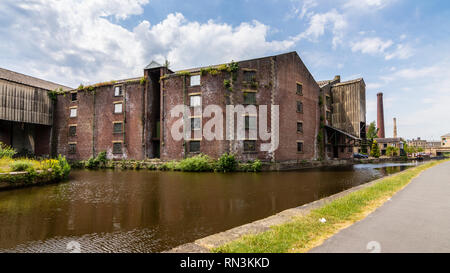 Shipley, England, Regno Unito - 1 Luglio 2015: tradizionale fabbrica di vecchi mulini e magazzini abbandonati stand su Merchants Quays accanto al Leeds e Liverpool può Foto Stock