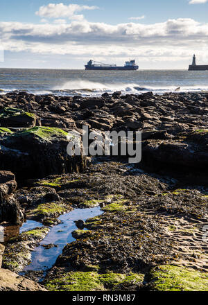 Tynemouth, England, Regno Unito - 4 Febbraio 2019: una nave lascia il porto del Tyne nel Mare del Nord mentre venti soffiano contro le onde del mare. Foto Stock