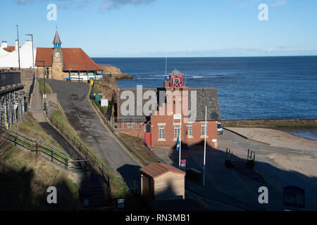 Tynemouth, England, Regno Unito - 4 Febbraio 2019: inverno il sole splende sul mattone tradizionale imbarcazione di salvataggio stazione a Porto Cullercoats in Tyneside. Foto Stock