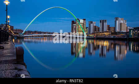 Gateshead, Regno Unito - 6 Febbraio 2019: Gateshead Millenium Bridge e il Baltic mulini sono accese al tramonto sul fiume Tyne Quays. Foto Stock