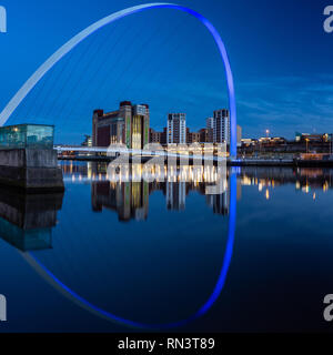 Gateshead, Regno Unito - 6 Febbraio 2019: Gateshead Millenium Bridge e il Baltic mulini sono accese al tramonto sul fiume Tyne Quays. Foto Stock