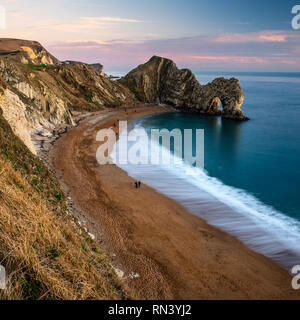 Il Dorset, England, Regno Unito - 27 dicembre 2018: la gente a piedi lungo la spiaggia e una scogliera costa percorso in corrispondenza della porta di Durdle su Dorset la Jurassic Coast. Foto Stock