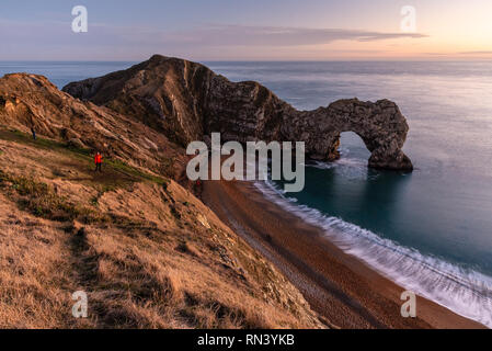 Il Dorset, England, Regno Unito - 27 dicembre 2018: la gente a piedi lungo la spiaggia e una scogliera costa percorso in corrispondenza della porta di Durdle su Dorset la Jurassic Coast. Foto Stock