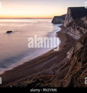 Il post-incandescenza del tramonto illumina il cielo dietro il bat la testa e la Baia di Weymouth su Dorset la Jurassic Coast. Foto Stock