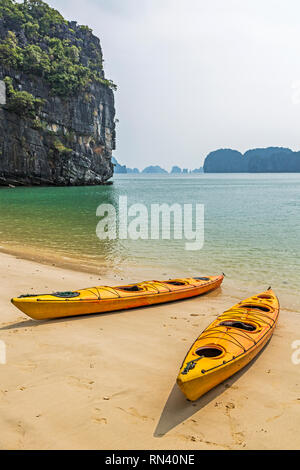 Canoe sulla spiaggia nella baia di Halong, Vietnam Foto Stock