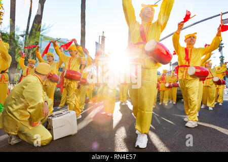 Il Falun Gong seguaci di colore giallo luminoso uniformi marciare in parata natalizia su Hollywood Blvd a Los Angeles, California. Foto Stock