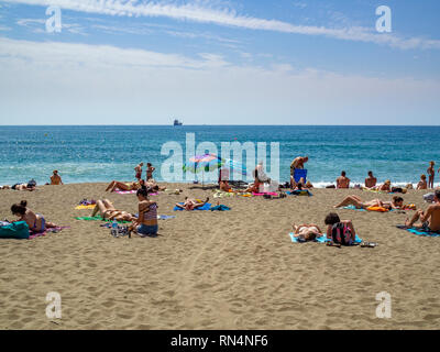 Persone sole a cottura a Playa de la Malagueta spiaggia di Malaga, in Spagna. Foto Stock