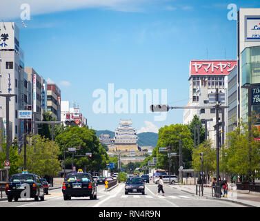 Una vista di Ootemae-dori (Ootemae Street), la strada principale e il castello di Himeji (Himeji-jo) in aumento in background, Himeji, nella prefettura di Hyogo, Giappone. Foto Stock