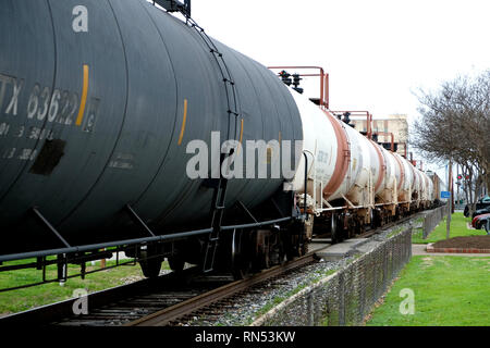 Treno merci con vetture di navi cisterna che passa attraverso il centro cittadino di Bryan, Texas, Stati Uniti d'America; trasporto chimico mediante vagoni ferroviari. Foto Stock