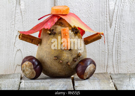 Dettaglio del divertente personaggio di patate con castagne Foglie di autunno su sfondo bianco Foto Stock