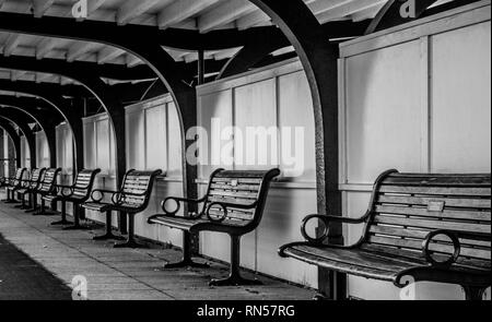 Una fila di panche sotto un riparo Foto Stock