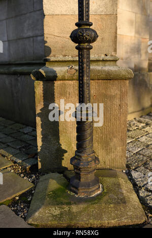 Ghisa lampada colonna montante montato su base di pietra nella parte anteriore della colonna di pietra ad angolo di tutti i santi stand chiesa in whitefield greater manchester regno unito Foto Stock