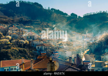 I fumi da stufe a legna nel corso di un tradizionale villaggio di montagna di Xanthi. Foto Stock