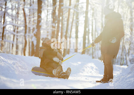 La famiglia felice godendo Sleigh Ride Foto Stock